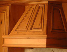 Close-up of a wooden kitchen cabinet with decorative paneling.