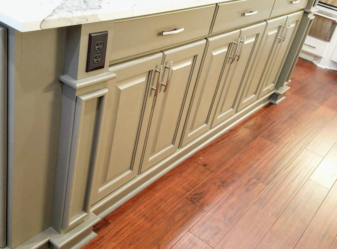 Kitchen island with exceptional custom furnishing, beige cabinetry, and stainless steel handles on a hardwood floor.