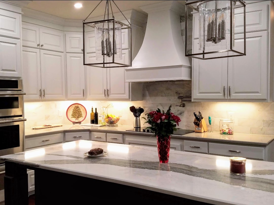 Elegant kitchen with marble countertops, white cabinetry, and exceptional custom furnishing.