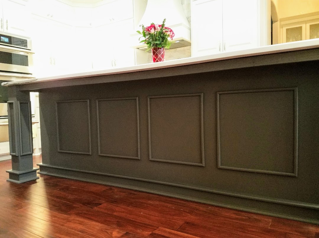 Elegant kitchen island with paneling detail and exceptional custom furnishing hardwood floors.