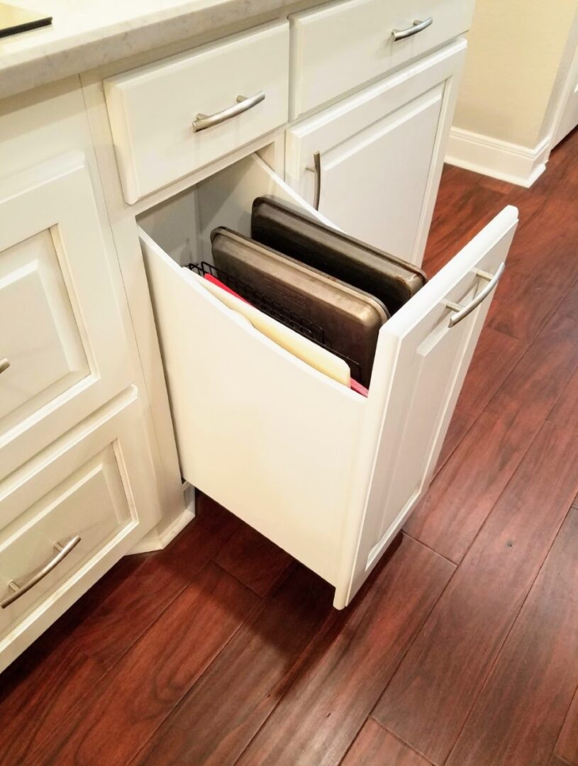 Exceptional custom furnishing: Cabinet drawer with built-in trash bins partly opened in a kitchen.