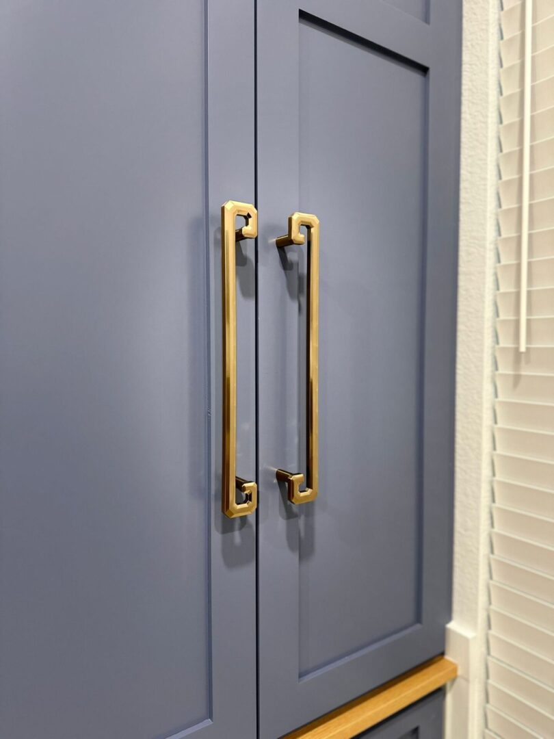 Gray cabinet doors with brass handles, an exceptional custom furnishing.