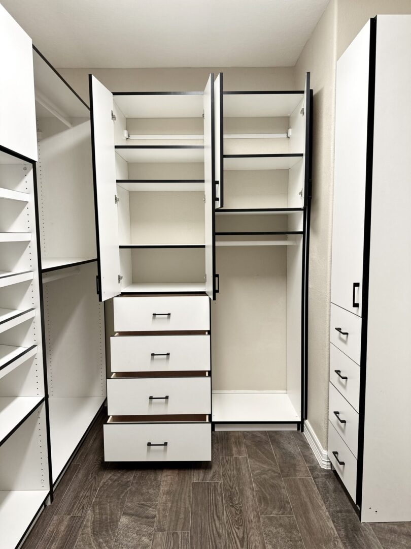 Empty walk-in closet with open drawers and shelving units.