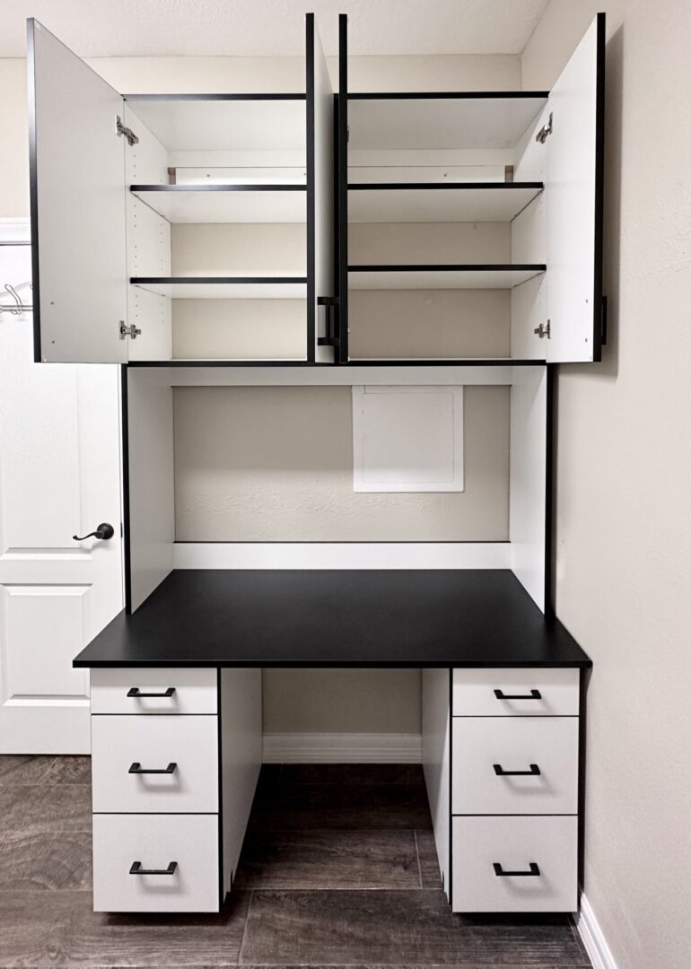 A white and black home office desk with overhead cabinets and drawers, featuring exceptional custom furnishing.