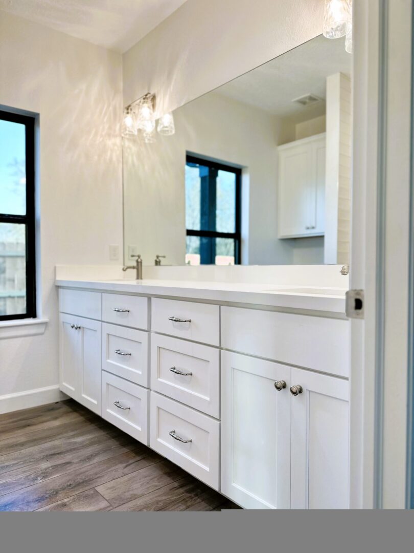 A modern bathroom vanity with white cabinets and a double sink, featuring exceptional custom furnishing.