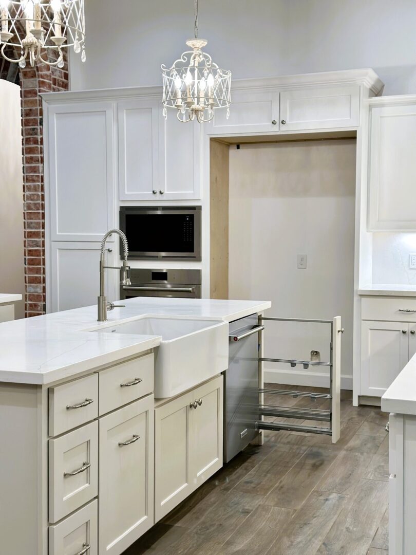 A modern kitchen with white cabinetry and an exceptional custom furnishing pull-out storage unit.