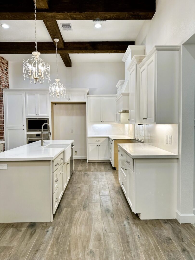 A modern kitchen with white cabinetry, exceptional custom furnishing, stainless steel appliances, and wood-style flooring.