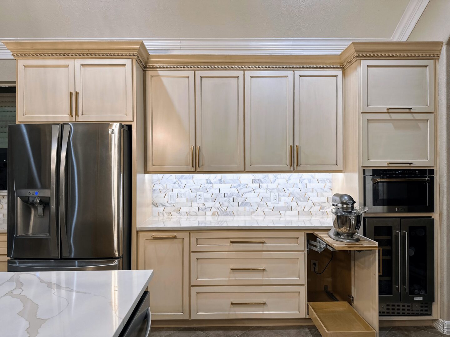 Modern kitchen interior with stainless steel appliances and white cabinetry.