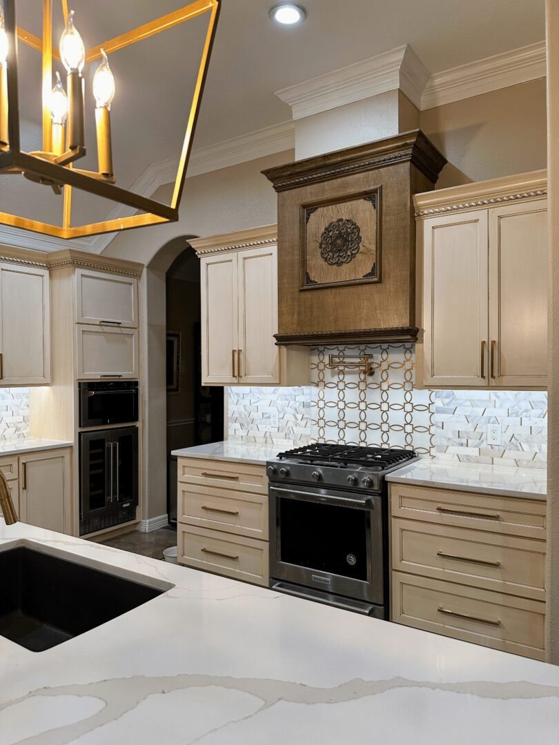 Modern kitchen interior featuring light-toned cabinetry, a geometric backsplash, and stainless steel appliances.