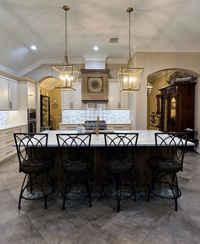 Elegant kitchen interior with a large island, pendant lights, and bar stools.