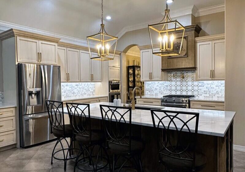 Exceptional custom furnishing in a modern kitchen with white countertops, stainless steel appliances, and pendant lighting over a center island with barstools.